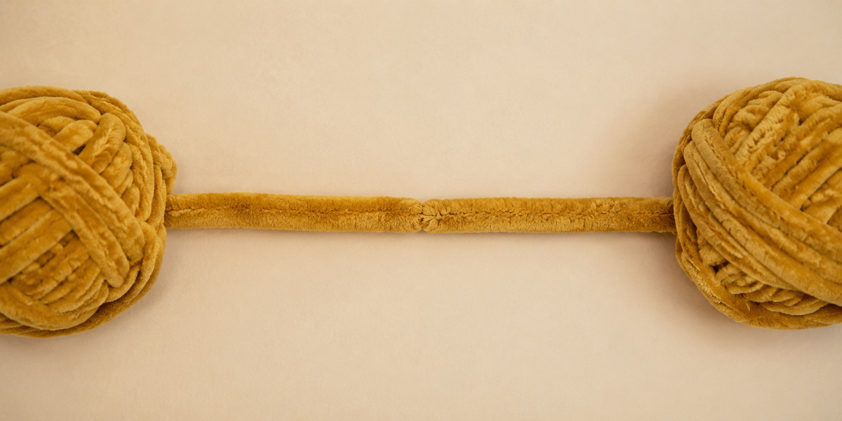 Deux pelotes de fil chenille XXL miel doré reliées par un raccord discret