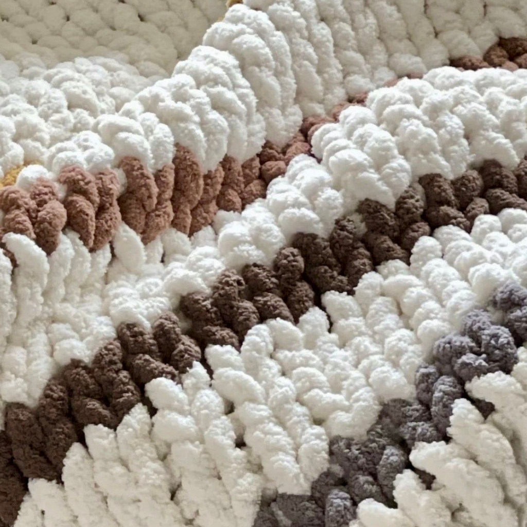 Texte descriptif: couvertures en tricot épais vues en gros plans, motifs chenilles colorées en blanc, crème, marron et gris. Tutoriel de mini-cours débutant.