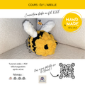 Chouette peluche jaune et noire avec oreilles blanches, crochetée, sur fond beige; logo “HAND MADE” et texte Tutoriel Vidéo + PDF Ély l’abeille.