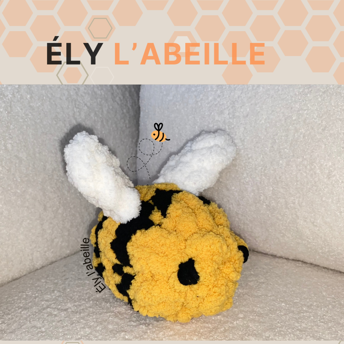 Petit animal en peluche jaune/noir (abeille) avec grandes oreilles blanches sur fond gris, label ÉLY L’ABEILLE. (Kit de création Ély l'Abeille)