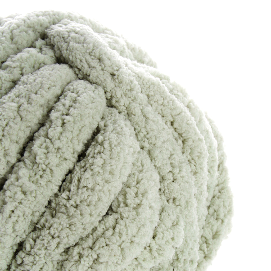 Sauge : gros plan d'une pelote de laine bouclée couleur vert pâle, texture épaisse et moelleuse.