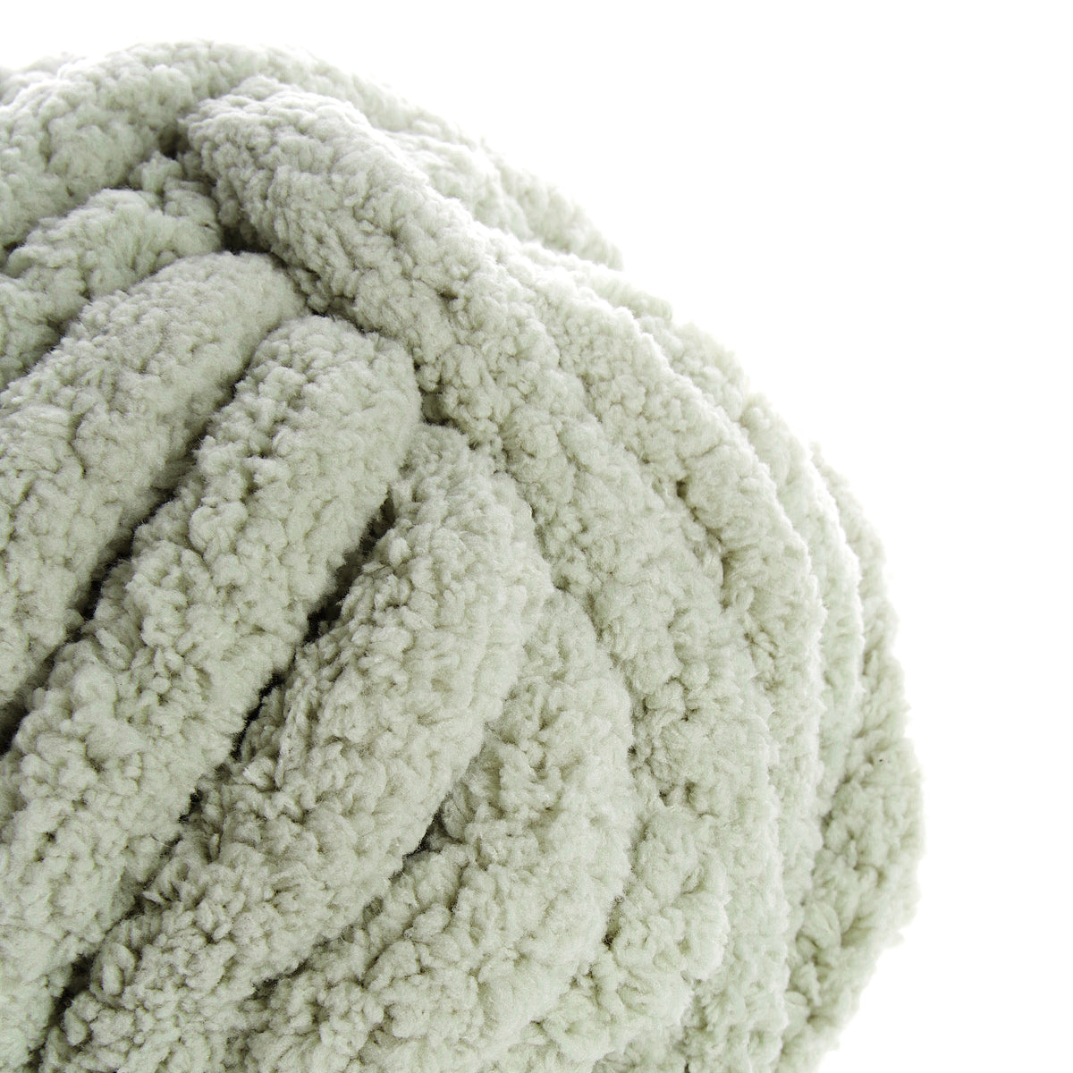 Sauge : gros plan d'une pelote de laine bouclée couleur vert pâle, texture épaisse et moelleuse.