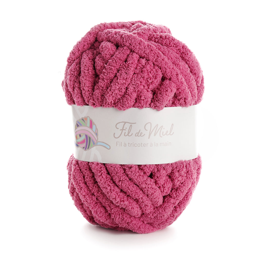 Pelote de fil à tricoter bouclé rose fuchsia, label blanc « Fil de Miel » avec motif pelote multicolore.
