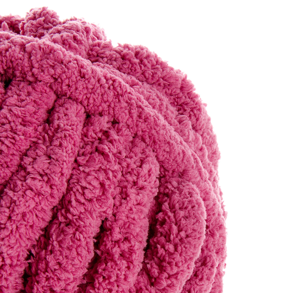 Tissu en peluche rose fuchsia bouclé, texture dense et moelleuse près d’un bord blanc. Mot-clé principal: Vieux rose.