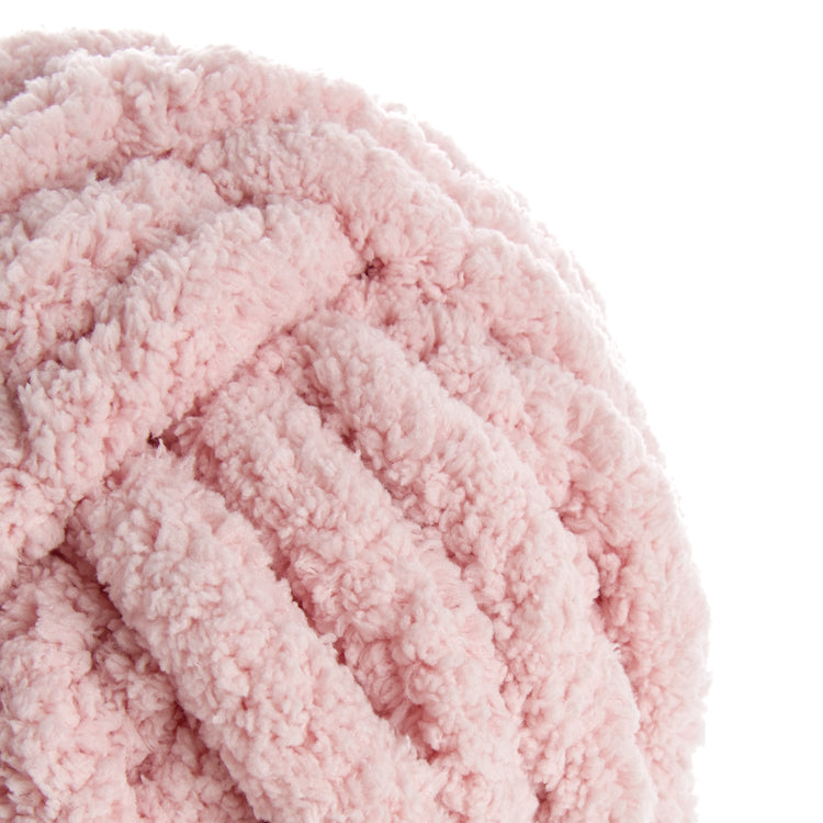 Pelote de laine rose poudré, texture bouclée et moelleuse, gros fil doux. Rose poudré, style peluché.