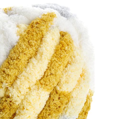 Texte alternatif: Gros plan sur une peluche épaisse et moelleuse couleur crème et jaune, texture fluffy, style velours bouclé. Alt inclut le mot clé Vanille grisée.