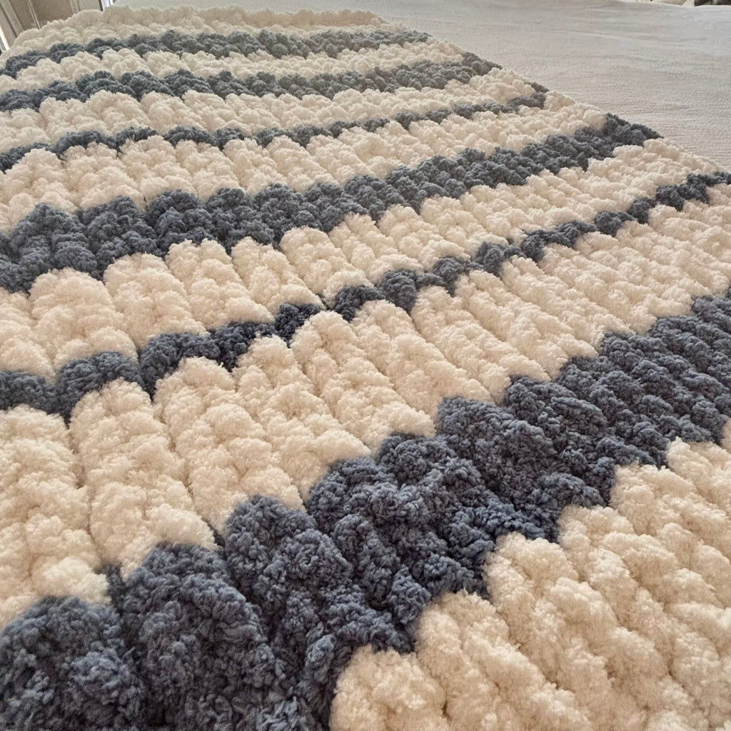 Couverture épaisse en tricot faite à la main, motif à bandes crème et gris, texture bouclée et moelleuse. Tutoriel - Mini-cours débutant.