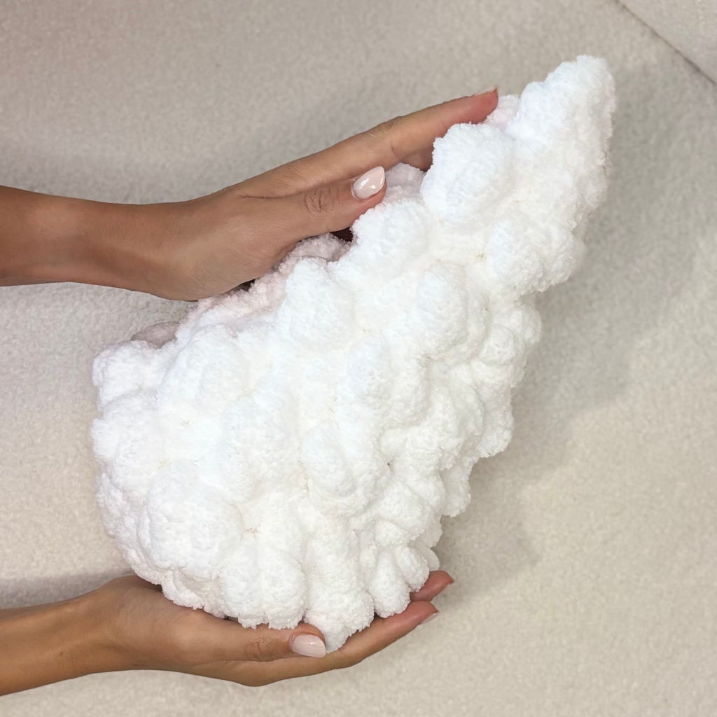 Gros flocon de neige synthétique blanc et fluffy, tenu dans les mains, prêt à être utilisé pour un sapin XXL.