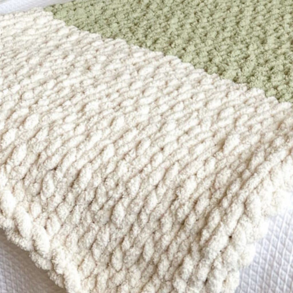 Bandeau de couverture tricotée épaisse beige au crochet main, texture pelucheuse sur fond clair.