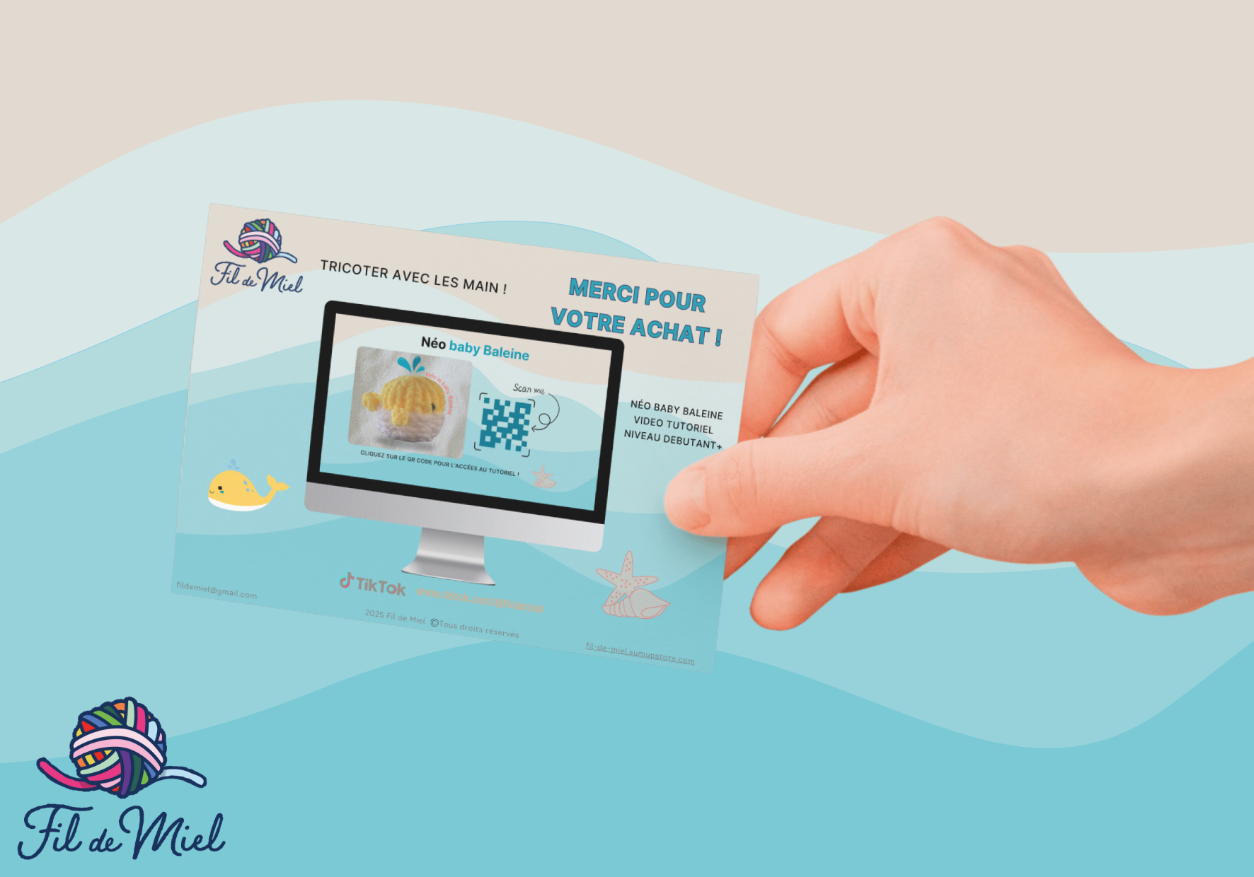 ALT: Carte promotionnelle du kit de création Néo le Baby baleine, montrant un écran d’ordinateur avec tutoriel et graphismes baleine et baleineau, tenue par une main.