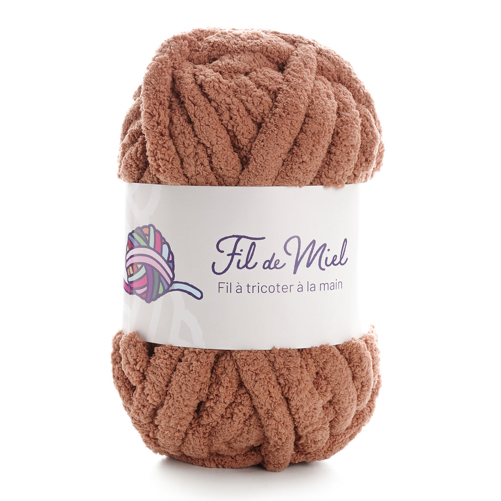 Fil de Miel: pelote de laine bouclé couleur caramel, épaisse et douce, avec étiquette blanche “Fil à tricoter à la main”.